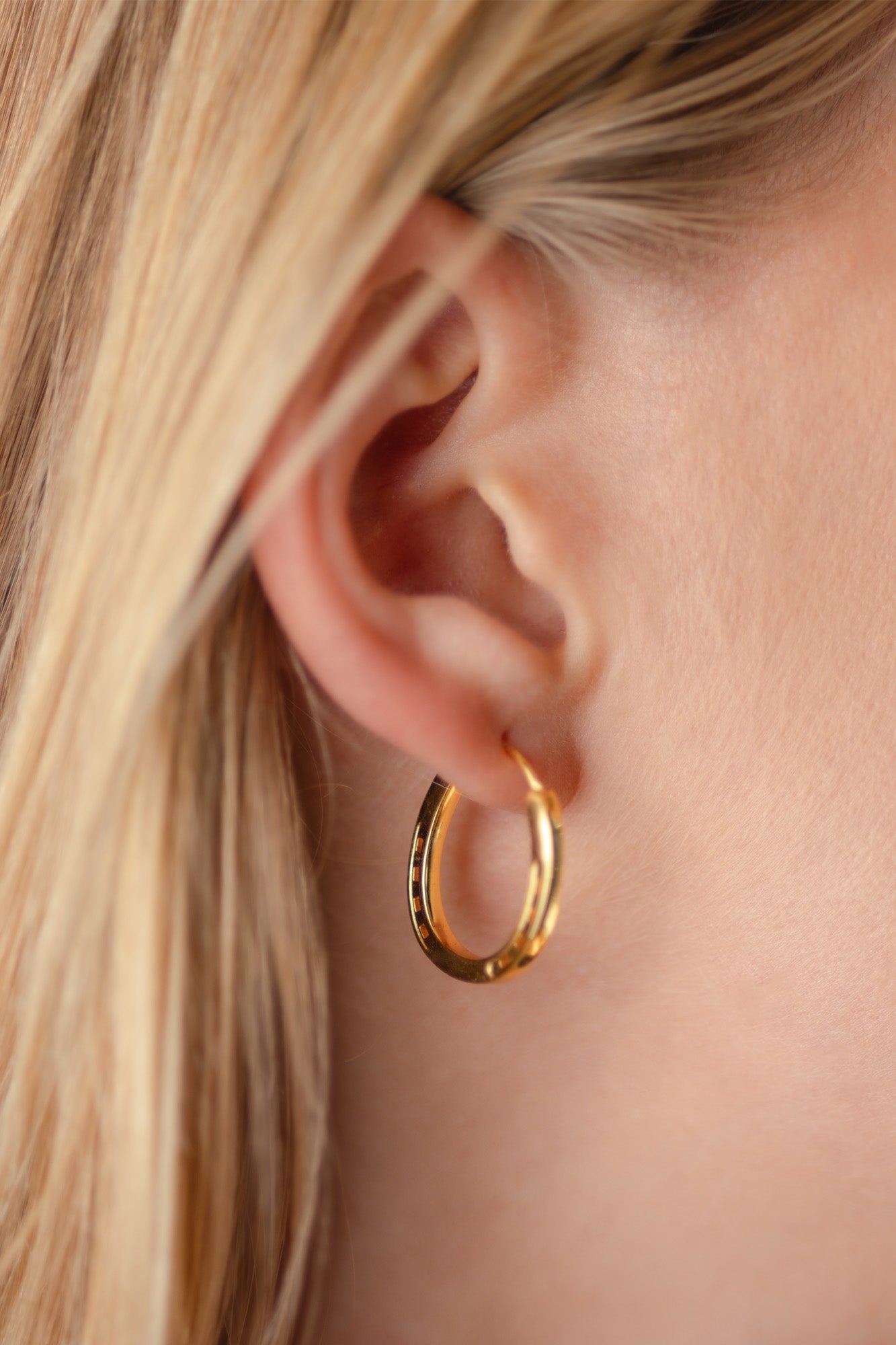 A close-up of a pair of elegant gold hoop horseshoe earrings on a blond model, emphasizing their gleaming finish and stylish form.
Our Gold Horse Shoe Earrings are unique equestrian gifts crafted from high-quality gold. This gold horseshoe earrings are the perfect equestrian lifestyle fan gift and a good luck charm. Our Horseshoe earrings are the perfect birthday present for horse lovers, horse girls, cowgirls. A representation of good luck.