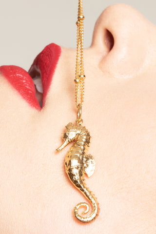 Our seahorse pendant is a gold charm elegantly displayed, showcasing its intricate design and craftsmanship.The pendant is shaped like a beautiful seahorse , with detailed features such as its fins and tail    Perfect for seahorse lovers, ocean inspired jewelry,  gold seahorse jewelry, unique gifts for girls. A dynamic piece of  Jewelry.